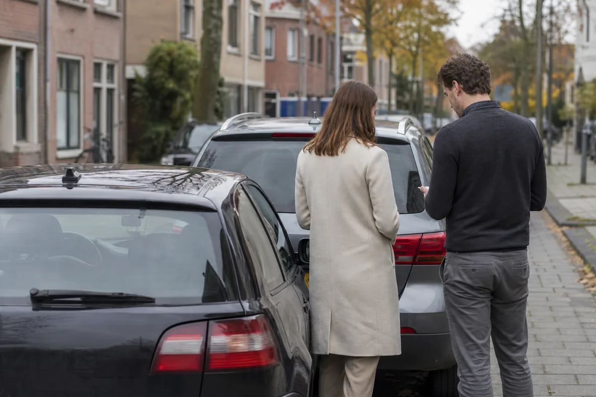 Twee auto's na een kleine kop-staartbotsing, bestuurders wisselen gegevens uit