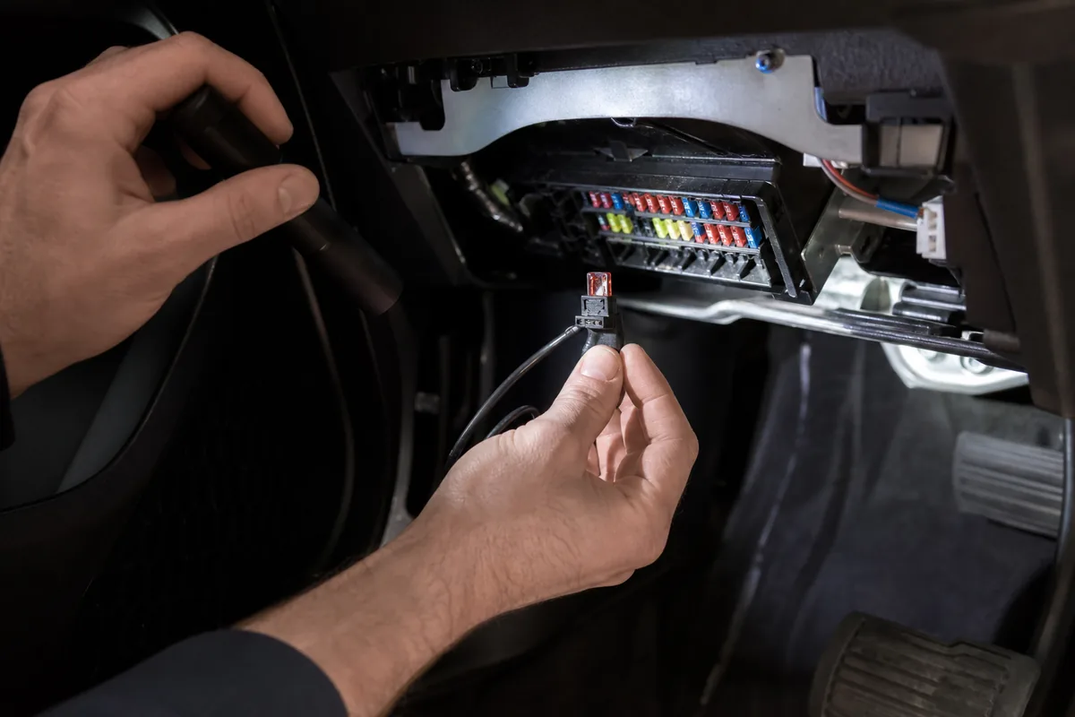 Een dashcamkabel wordt met een zekeringtap aangesloten op de zekeringkast van een auto